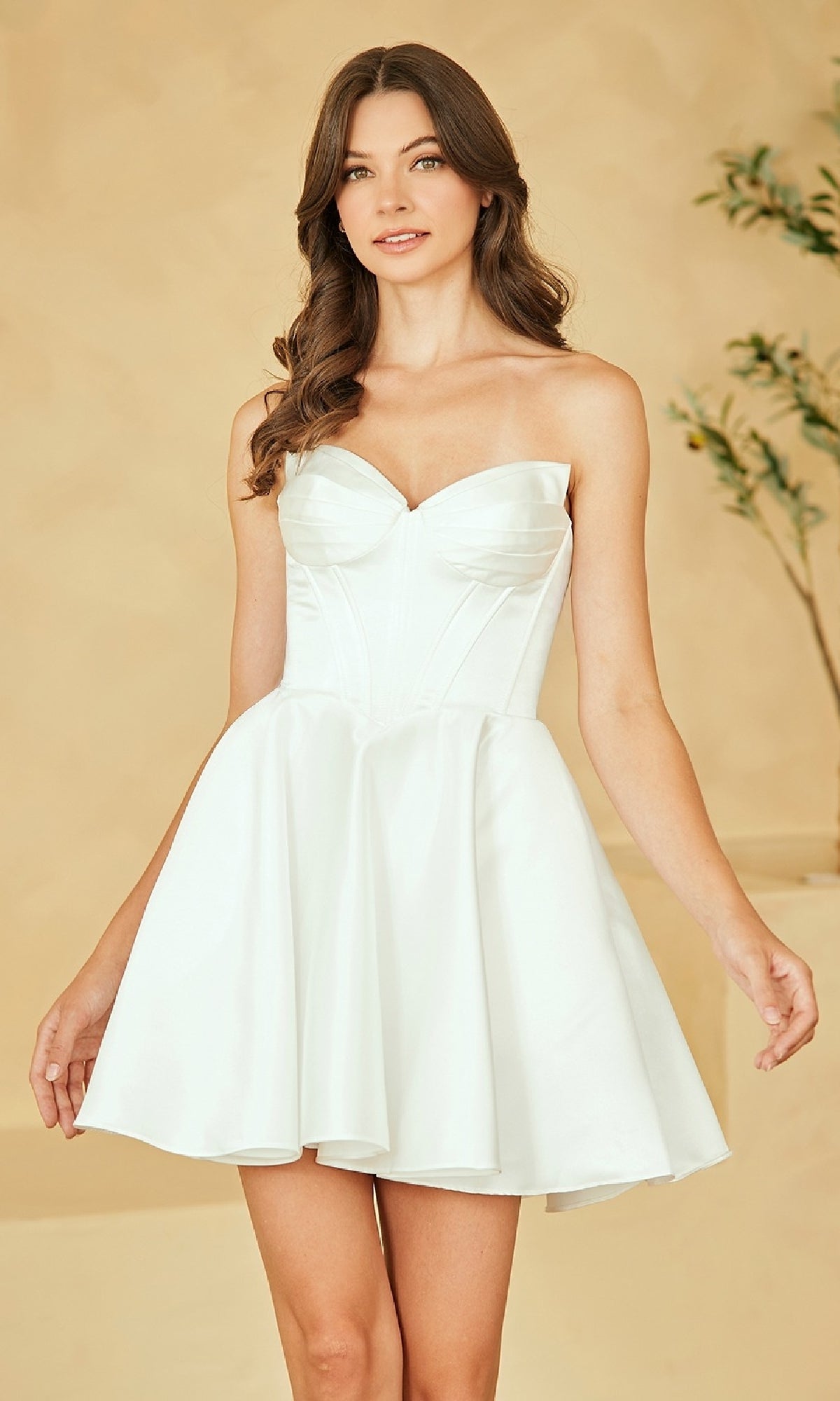 Woman wearing a white strapless short a-line dress against a beige background